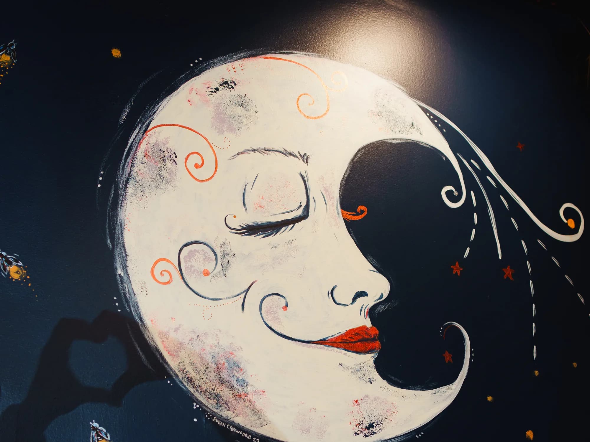 The hand-painted crescent moon mural on the deep navy wall at Corbet Street